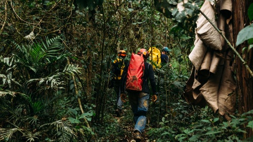 Cavers walk through a tropical forest, passing huts and farmers to access Cueva De Linda, a beautiful horizontal limestone cave in Acquismon.
