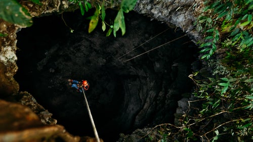 Jerry Cindric stares into a blackness as he rappels into Sotano De Cepias (412 feet). When rappelling into these pits, it is hard to tell when the rope has reached the bottom of the cave. Cavers tie a knot on the end of the rope to ensure they don’t rappel off of the end and fall to their deaths.