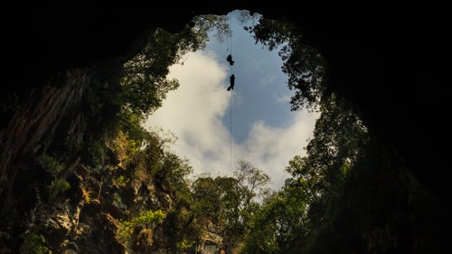 American cavers were first to descend the 1,200-foot deep Sotano De Las Golondrinas, better known as the Cave of Swallows, in 1966. It’s one of the world’s largest cave shafts in the world and one of Mexico’s 13 natural wonders. The cave is so enticing that, in 2012, then President of Mexico, Felipe Calderon, was lowered by rope to the bottom of the shaft to experience it first-hand.
Today, there’s a paved road leading to the entrance of the cave to encourage tourism, and people from all over the world visit to peer over the edge and watch the white-collared swifts who call the cave home. Very few of these vistors actually rappel inside to see the bottom. Despite the popularity of this natural wonder, the inside of the cave is still a genuine wilderness experience. The limestone karst of the area of Acquismon is home to many caves, Sotano de Golondrinas being only one of them. Here is a collection of photographs from the Cave of Swallows and other shafts surrounding it.
Photo: Scott Christenson and Jerry Cindric ascend out of Sotano De Huasteca, a 420-foot deep limestone pit in Aquismon. Using mechanical ascenders to climb the rope, they are able to quickly and efficiently exit the cave. Rock climbing the walls in the cave would disrupt the nests and habitat of the white-collared swifts. Leaving behind climbing chalk and climbing bolts would be unnecessary to explore the cave and is damaging to the fragile ecosystem.