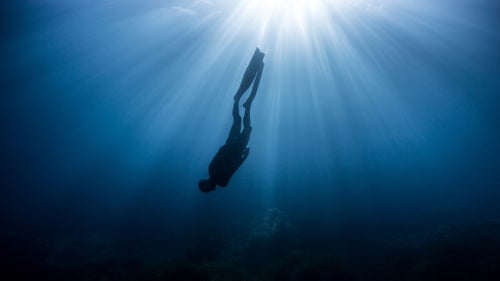 Eusebio descends into the darkness of the deep Mediterranean ocean near Ibiza, Spain. What impressed us the most about photographing the sea surrounding Ibiza were the long twilights that created magical and eerie light beneath the surface.