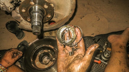 Repairing the wheel bearing in the middle of the night in Brazil. Important tools we always carry: a good socket set, special tools for wheel bearing and fan repair, a Nanocom to read the vehicle ECU, and a Leatherman. For spares, we have air, fuel, and oil filters, wheel bearings, oil, lubricants, and replacements for parts we predict are going to fail.