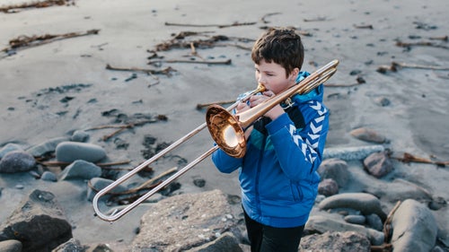 Sim煤n Jacobsen playing trombone on the beach of Sandav谩gur on Vagar Island.