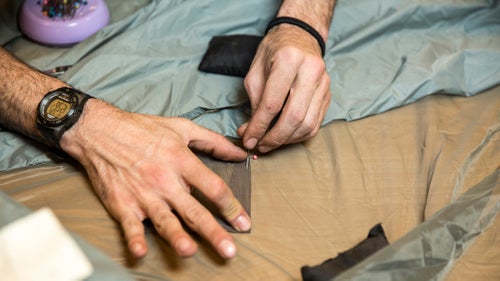 Jacobson prepares to patch a tent.