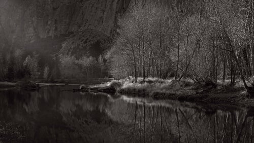 Shot along the banks of the Merced River as the last few rays of sunlight surged down the tunnel of Yosemite valley. The looming base of El Capitan, and lack of a horizon line, gives a sense of the scale of the rock formations in this area.