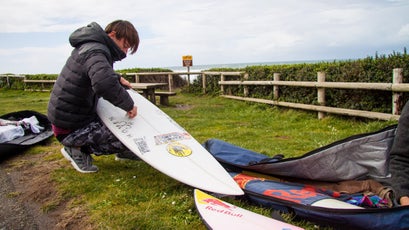 Jamie's buddy Kaikea Elias waxing his board before heading into the choppy and chilly Pacific ocean.