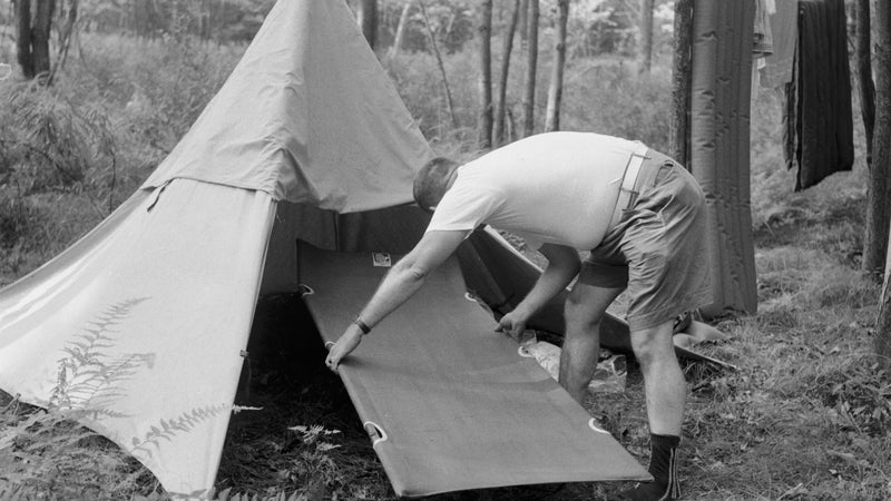 circa 1955:  With his tent set up for an adventure holiday, a camper realises that his camp bed is too large for the tent.  (Photo by Jacobsen /Three Lions/Getty Images)