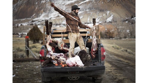 Josh loads buffalo quarters into a Native American hunter's truck.