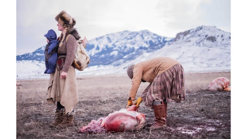 Ania pulls buffalo fat from a gut pile as Epona waits with backpack. Buffalo Bridge will occasionally be gifted a hide, bones, and even organs like the heart and liver.