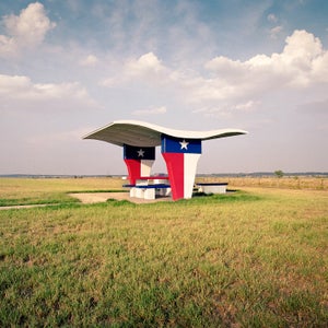 When photographer Ryann Ford moved to Texas in 2007, she began driving across the state, accepting photography assignments in every corner. Ford would take the quickest, main highways on her way there and look for the more scenic routes on the way back. This is where she found remnants of America’s beautiful and often crumbling rest stops. Due to the recession of the late 2000s, many of these great pieces of Americana were destroyed or left to decay. Ford made it her mission to capture as many as she could before they were gone. Her latest book, The Last Stop, is a stunning collection of charismatic rest stops across the country. Here, Ford shares some of her favorites and a few stories from the road. 
Photo: lower Mound, Texas, I-35. This was the rest stop that inspired the project. As I researched rest stops to see what was beyond the Austin area, I was excited to find a photo of this one, and then shocked to read it would soon be demolished. The next weekend, I drove four hours north to shoot it. Sure enough, it was demolished a few weeks later.