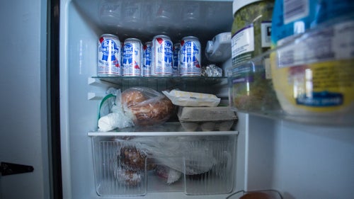 A well-stocked fridge, with eggs and beer.