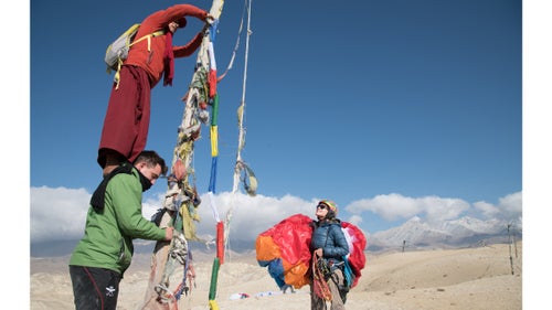 Isabella Messenger watches as a local lama hangs a new string of prayer flags above the city of Lo Manthang. This became the site of our first flight in the Mustang at 3900 meters in elevation.