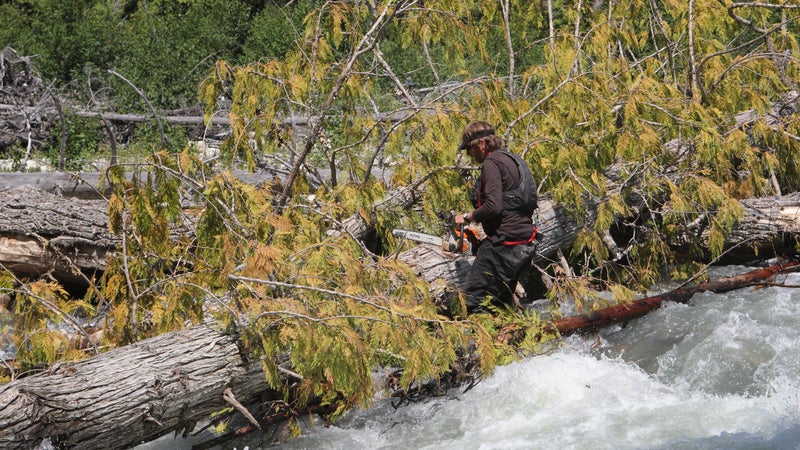 Man with long hair is fishing at river corner from raft. Boats and floating  houses are around him with trees in background. He is using fishing rod wi  Stock Photo - Alamy