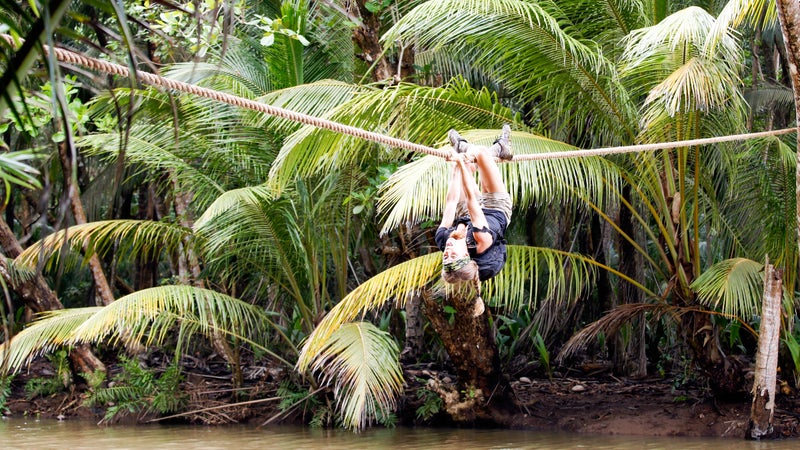Kim crossing the rope line upside down.