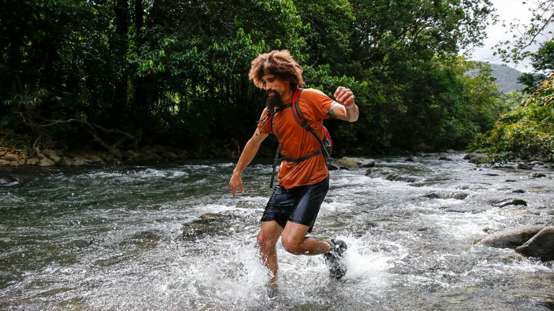Jeremy running through the edge of the large river.