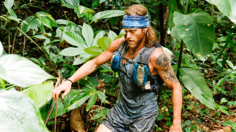 Tim Olson walking through a creek.