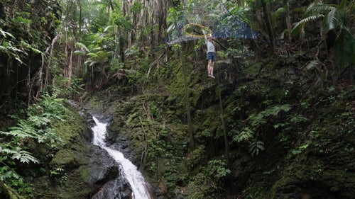 Mason tests out a handmade Space Net. The muddy, slippery terrain in Hilo makes it difficult to set the slacklines. Even worse: Mason and Lewis say there are swarms of fire ants.