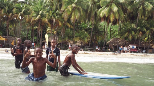 Young men heading into the water between heats to catch some waves and keep practicing. Once they've been up on a board it seems almost impossible to stay away.