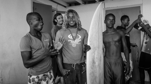 Jules reacts happily as contest winner Papito Santana donates one of his boards to another member of Surf Haiti. 聽