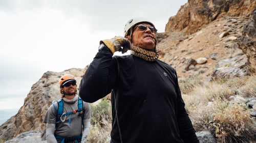 Swaney plays with a snake in Sand Witch Canyon while Plummer looks on. I鈥檝e visited Death Valley more than 30 times and had never seen a snake. Every day I spent with Swaney, he found at least one. May 21, 2016.
The weather is pleasant. We鈥檙e up around 5,000 feet, and it鈥檚 not too hot. We down-hike the drainage just a few hundred yards and reach our first rappel. Swaney and Plummer scope out potential anchor points. Gezik finds a little pool of standing water in a rock and scoops it into her bottle, using her bandanna as a filter. 鈥淧lenty of UV,鈥 she says to explain its potability. There鈥檚 a desiccated, twisty tree growing near the edge of the rappel, and Swaney declares it perfect. He loops webbing around it, clearing a couple twigs out of the way, and then attaches a rapide quick link. Once the rope is thrown over the edge, he inspects its lie. The stone is sharp where it transitions to vertical. Swaney uses another rock as a hand sander to smooth the lip. 鈥淭his could cut the rope,鈥 he says. 鈥淭ry not to pendulum or bounce.鈥
