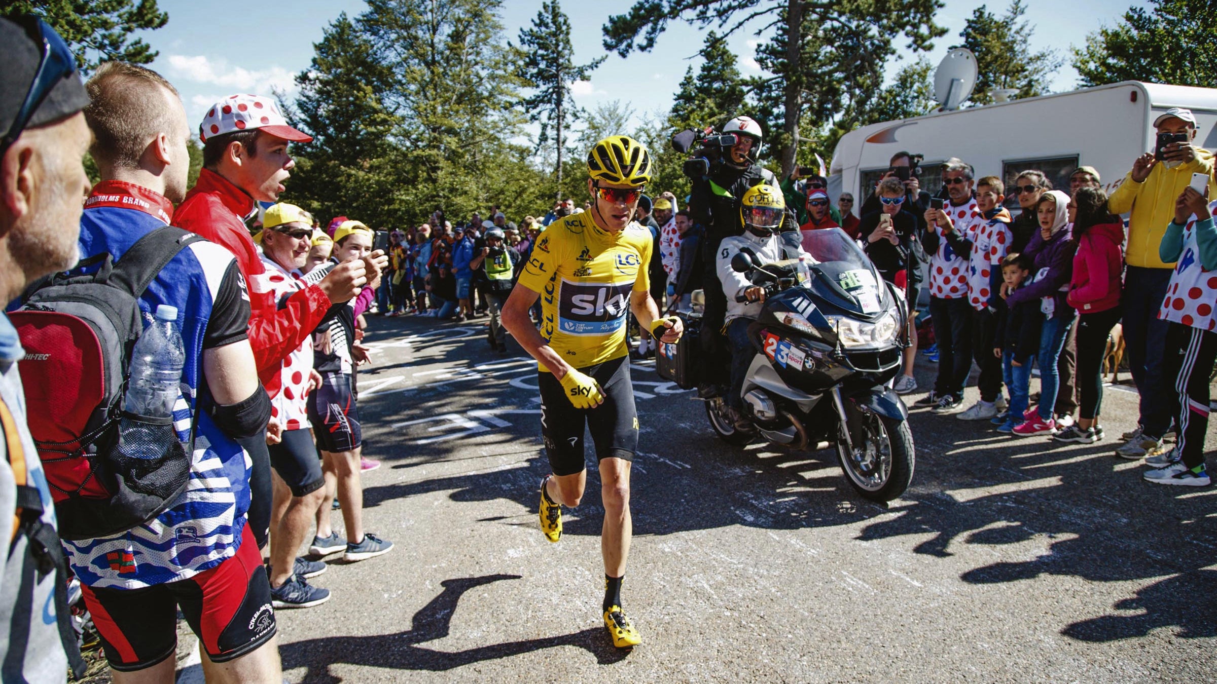 Chris Froome running after being involved in a crash after he ran into back of a motorbike that had stopped due to the large crowds.