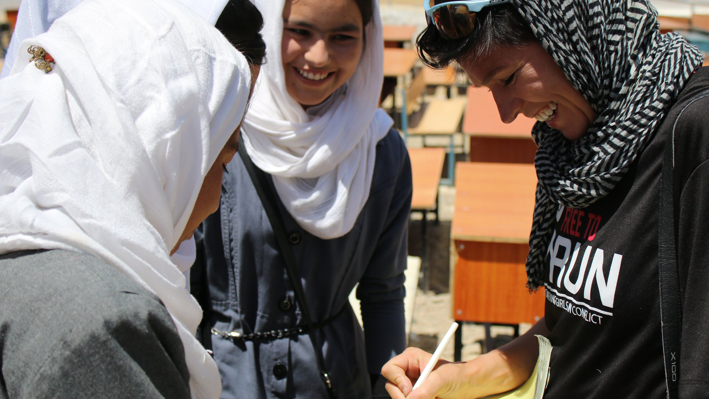 Students at a local girls’ high school crowd around Stephanie Case, founder of Free to Run.