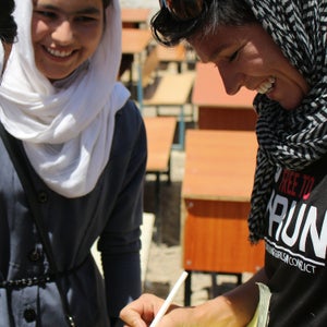Students at a local girls’ high school crowd around Stephanie Case, founder of Free to Run.