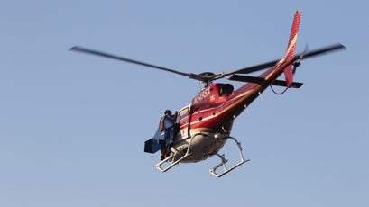 Rex holds on to the helicopter as it takes him up to 10,000 feet for his first flight