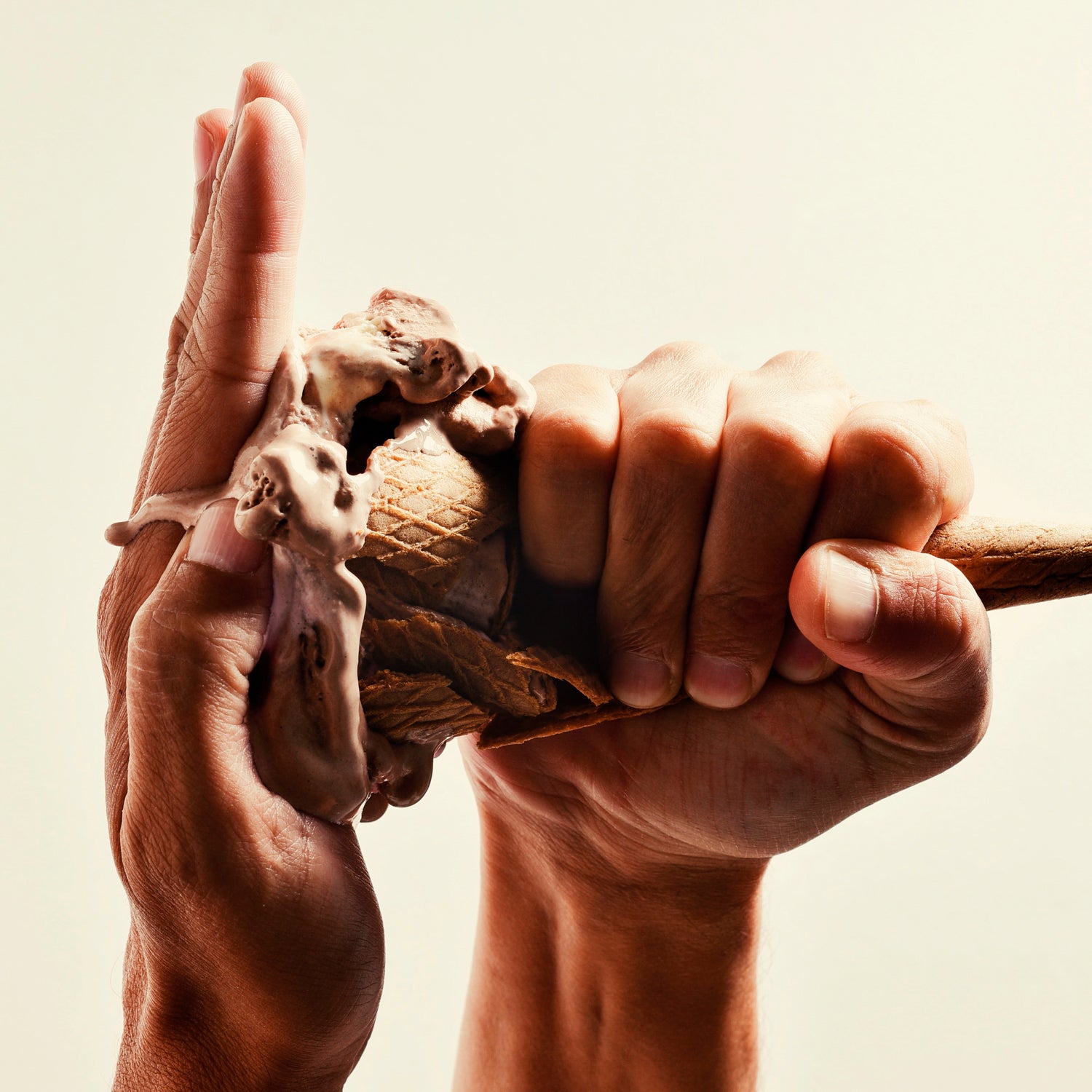 man smashing a chocolate ice cream in his hand