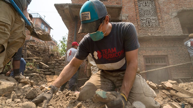 Team Rubicon member Tim Fortney looks for valuables lost underneath the rubble.