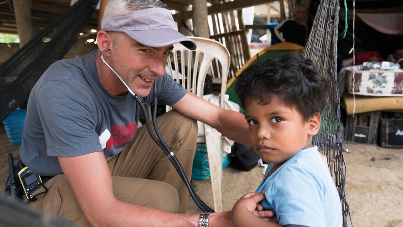 Team Rubicon member Scott Seager listens closely to the breathing of an Ecuadorian child in Bahia, Ecuador.