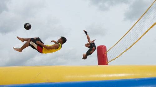 Similar to volleyball, the Belgian sport of bossaball also includes elements of soccer, gymnastics, and the martial art capoeira. Each side of the court has an integrated trampoline, allowing players to bounce high enough to spike the ball. In this photo, players warm up prior to a training session in Holland.