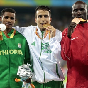 Silver medalist Tamiru Demisse of Ethiopia, gold medalist Abdellatif Baka of Algeria and bronze medalist Henry Kirwa of Kenya celebrate on the podium at the medal ceremony for the Men's 1500m