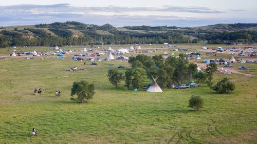 Night falls on the camp near the Dakota Access Pipeline on the edge of the reservation. Protesters first began camping here in early April, before the last winter snow had melted. By late August, thousands of people were camping in the area. Today, most of the open space in this photo is occupied.