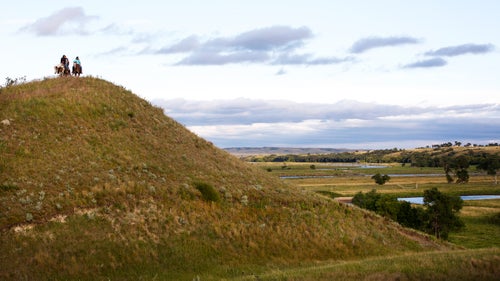 Riders stand on a hill above the confluence of the Missouri and Cannonball rivers on a warm August evening. This terrain, a lush bottomland of channels and marshes, is held sacred by the Sioux. It is also claimed by the U.S. Army Corps of Engineers, which uses it as a floodplain for the Oahe Dam, downstream on the Missouri.