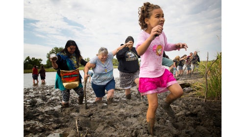 Isabella Flannery (9) of Kansas City, Missouri, picks her way through deep mud after praying with her mother, Stella, and other women on the banks of the Cannonball River near camp. Isabella and Stella came to North Dakota out of concern that if an accident occurs and the pipeline spills crude into the Missouri River, it will pollute not only Standing Rock鈥檚 water supply, but also their own and that of many others who live downstream.