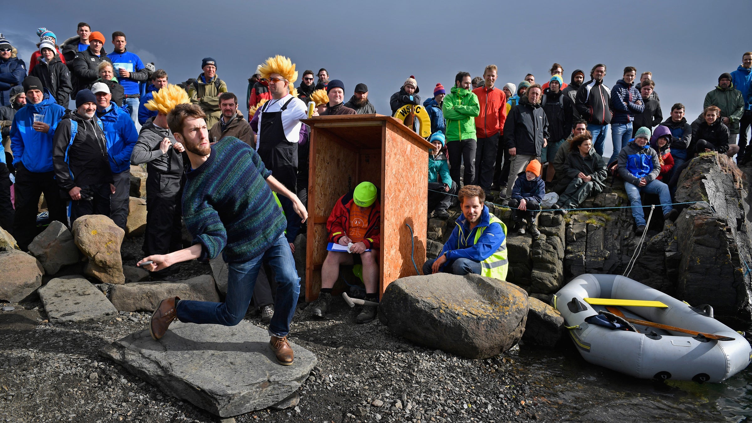 Competitor Alistair Brown at this year's World Stone Skimming Championships. Donald "Melon" Melville sits in the booth at center.