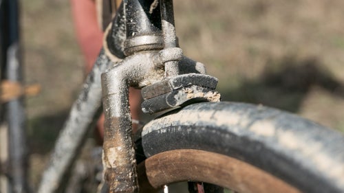 Long before the birth of disc brakes, V-brakes, and cantilever brakes, there were tire brakes. This example on an early 1900s safety bike shows the white mud of the Tuscany roads. Note the wooden rim.