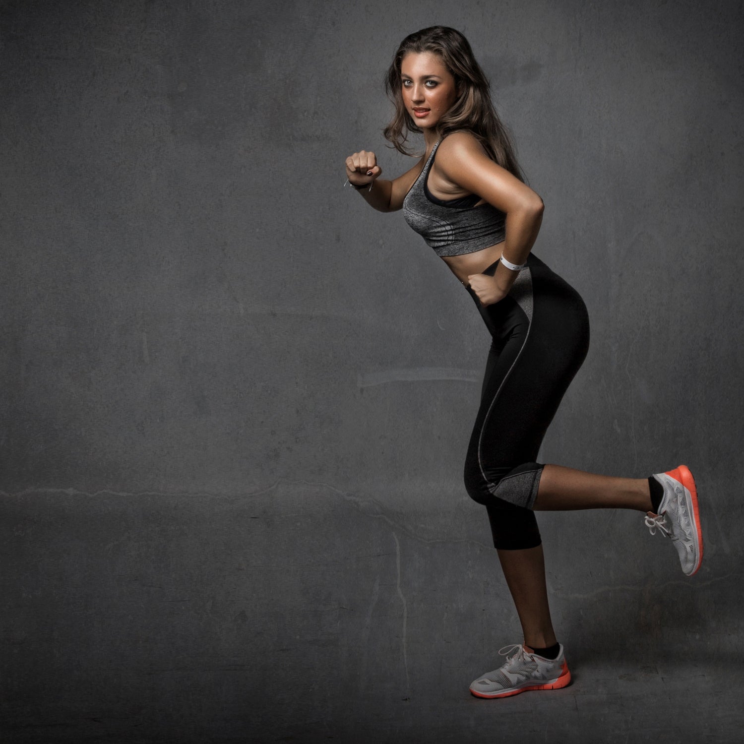 A smiling fitness woman in sportswear poses for a portrait after a workout  at the gym isolated on a gray background 27184226 Stock Photo at Vecteezy