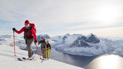 This past March, I flew to the island of Senja, Norway, to take part in one of the many self-powered backcountry programs offered by Pure Ski Touring. The island is part of a 612-square-mile archipelago that sits in one of the northernmost, least-populated counties in Norway. Camilla Antonsson, founder of Pure Ski, says that of all the touring trips the company offers around the globe, Senja is definitely the most isolated.
It’s also the most inviting, with hundreds of low-angle approaches, no high altitude requiring acclimation, and relatively little avalanche danger—gusts of warm air from the ocean make the layers of snowpack dense and reasonably stable.
During five days of skiing, our group was treated to mind-blowing views of young, jagged, shark-tooth spires of rock that form battlements against the Arctic Ocean. All we could see were the blue-black sea, white peaks, and the kind of sharp light found only near the poles.