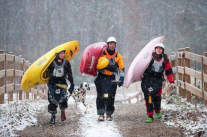 Dane, Eric and Emily Jackson shoulder their kayaks as their dog, Roxy, follows close behind near their home in Rock Island, TN.