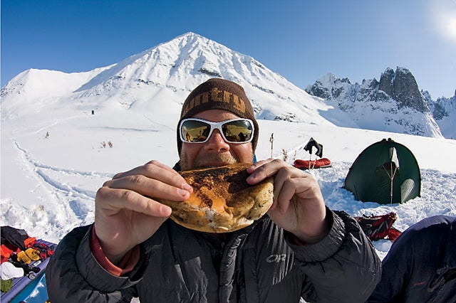 Drew Pogge eating a Man-cake at basecamp at Divide Lake