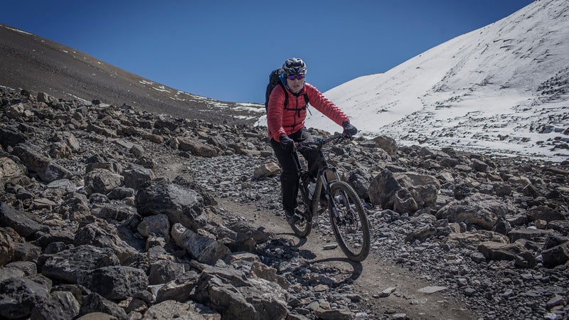 October 22, 2013 - Annapurna, Nepal - After crossing the 5,416m Thorung La Pass on the Annapurna Circuit, a group of mountain bikers rode along a narrow path through rock scree down the mountain towards the town of Muktinath and the historic Kali Gandaki Valley.