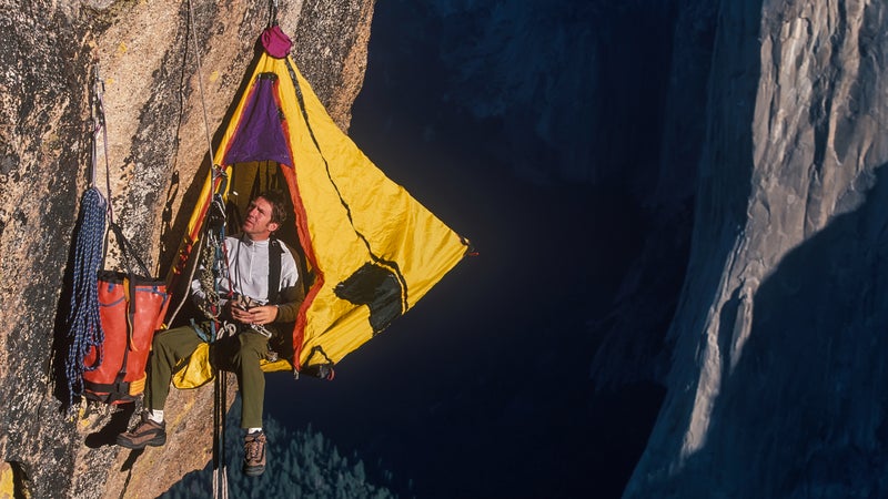 Climber in his hanging camp sleeps on the side of a mountain.