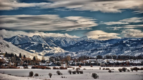 Houses dot the horizon beneath snow-covered mountains in Jackson Hole, Wyoming.