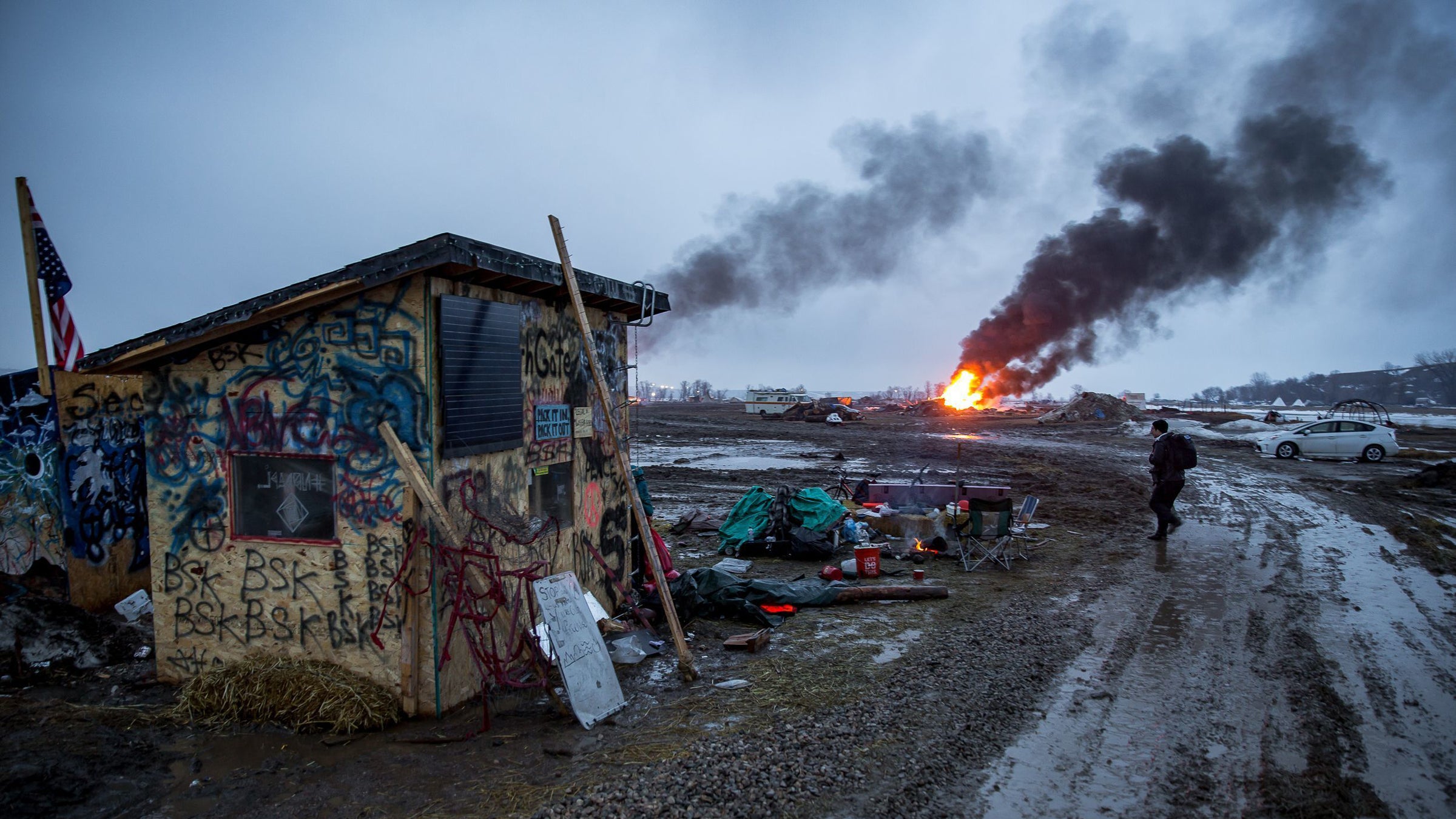 Campers set fire to structures in preparation for the 2pm deadline to vacacte the Ocetisakowin Camp in North Dakota. 