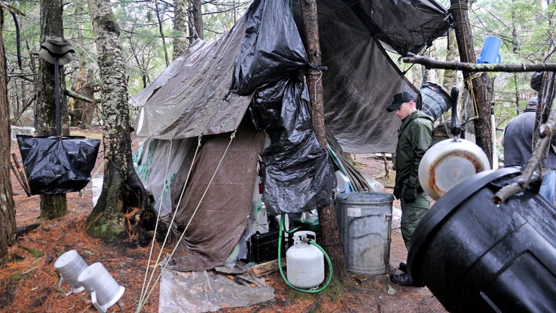 District game warden Aaron Cross inspects Christopher Knight's camp on April 9, 2013, in a remote, wooded section of Rome, Maine.