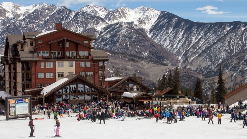 A crowd of skiers and snowboarders hang out at the base area of Purgatory ski resort in Durango, Colorado.