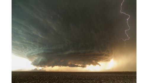 My earliest memory of a storm was watching lightning in the backyard with my dad when I was a kid. A bolt hit so close that I remember being blinded by it. Perhaps that’s why, when I became interested in photography in my mid-30’s, I focused on these electric events. Soon I was chasing supercells and tornadoes on the central plains. It’s exhilarating. I’m based in Phoenix, and for three months last spring I drove to and from the plains, chasing for 18 total days and putting over 25,000 miles on my Toyota 4Runner. You almost need to be an addict to get the shots I get. You’ll drive all night to Colorado, never sleep, chase all afternoon, get incredible images, then drive to Texas the next day, maybe get a few more hours of sleep, and then chase again that afternoon. Then repeat—maybe in Kansas. The following are my favorite shots from the six years on the road. Photo: A post-apocalyptic-looking supercell spins over the dusty farmlands of the Texas Panhandle.
All images by Mike Olbinski.