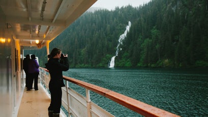 A woman photographs from an UnCruise ship in southeast Alaska.