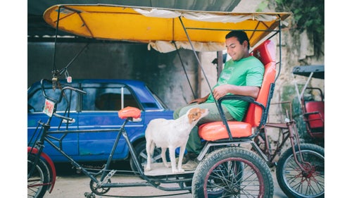 After flying into Havana, we waited for our Santiago shuttle at a bike taxi stand. This gentleman had a co-pilot.